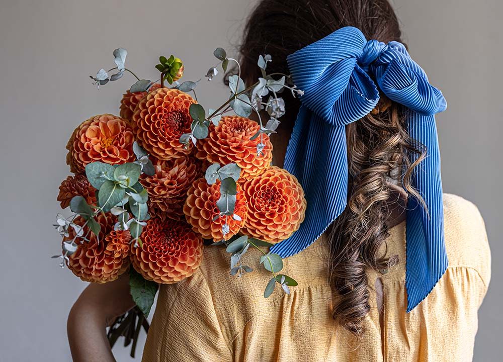 a-young-woman-holds-a-bouquet-of-chrysanthemums-fl-DDLHBJP.jpg