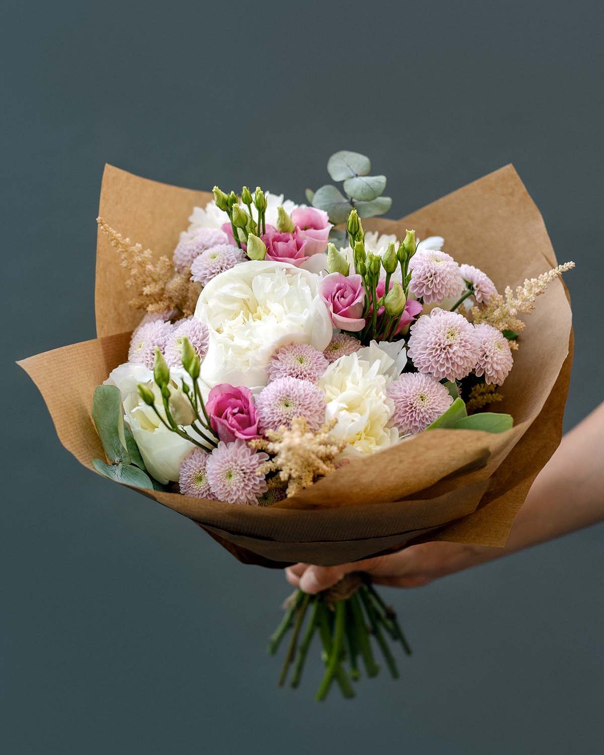 woman-s-hand-holds-a-bouquet-of-peonies-J6H8ARZ.jpeg